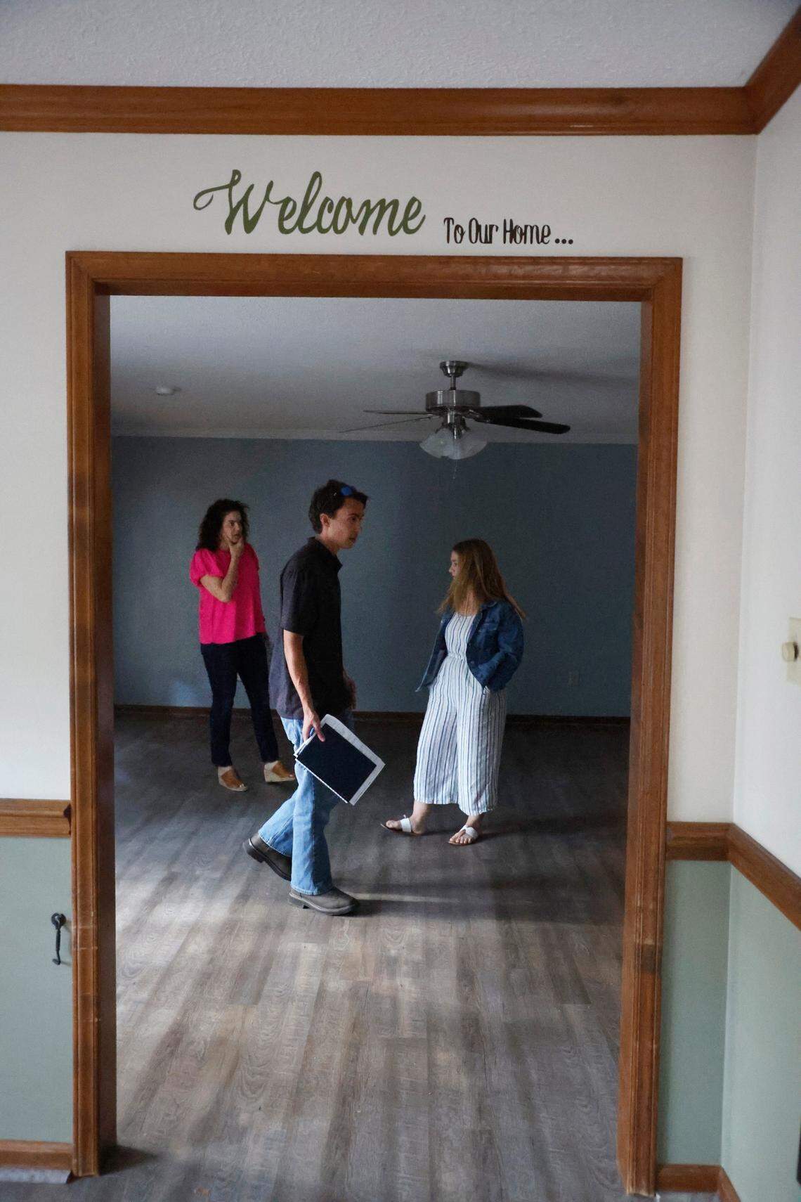 Brandon Thomas, his fiancee Corinne Enlow and Realtor AnnMarie Janni look over a home in Clayton while touring houses for sale in Garner and Clayton, N.C., on Tuesday, May 2, 2023.
