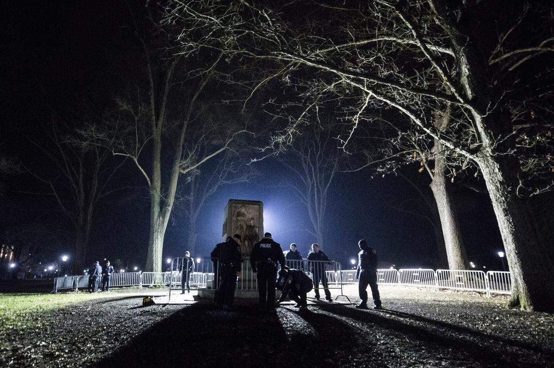 UNC-Chapel Hill police officers begin dismantling the barrier surrounding the pedestal on McCorkle Place where Silent Sam once stood on Monday, Jan. 14, 2019.