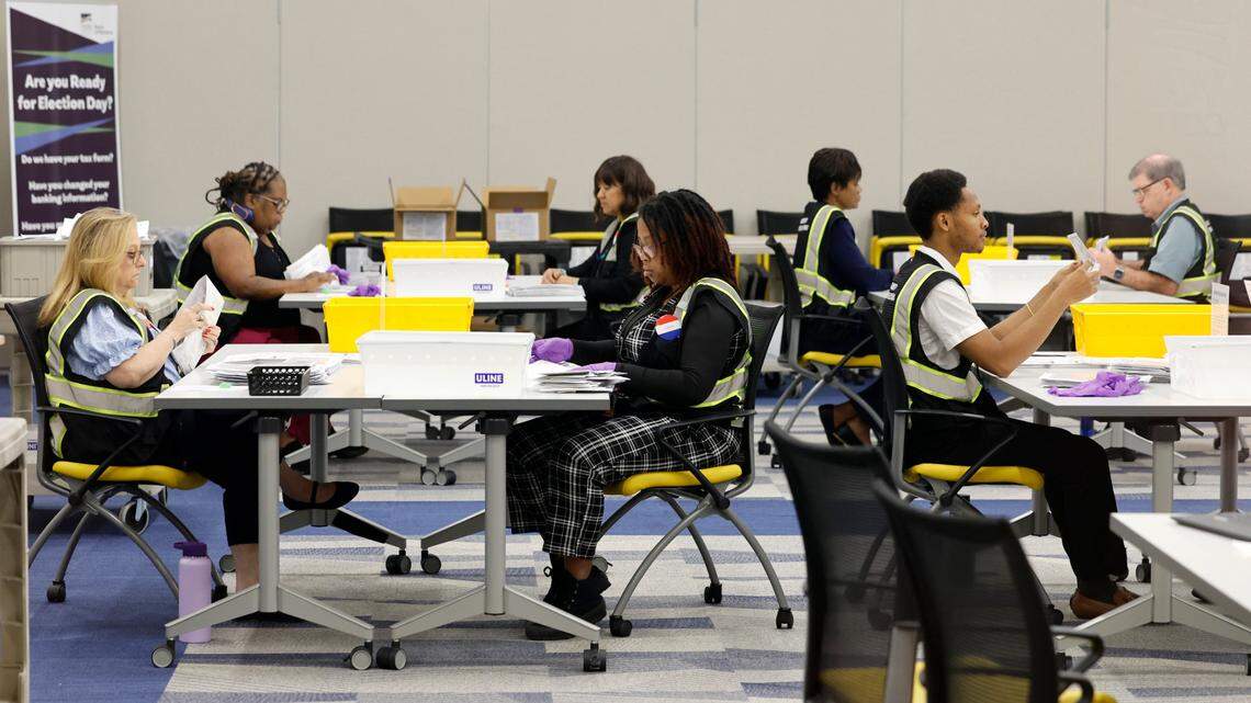 Board of Elections workers open, straighten and flatten approved absentee ballots at the Wake County Board of Elections Operations Center in Raleigh, N.C., Tuesday, Oct. 8, 2024.