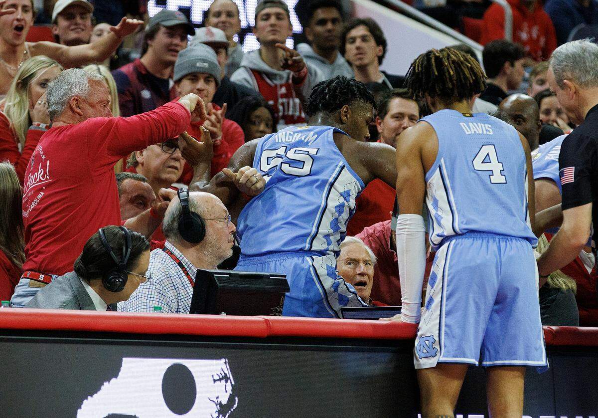 North Carolina’s Harrison Ingram climbs out of the crowd after diving out of bounds during the second half of the Tar Heels’ 67-54 win over N.C. State at PNC Arena on Wednesday, Jan. 10, 2024, in Raleigh, N.C.