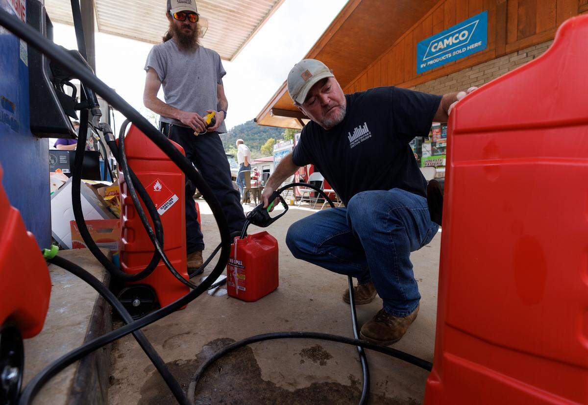 Craig Buchanan, right, fills up a gas can at Spear Country Store & Hardware on Thursday, Oct. 3, 2024, in Newland, N.C., days after Hurricane Helene brought severe flooding to the region.