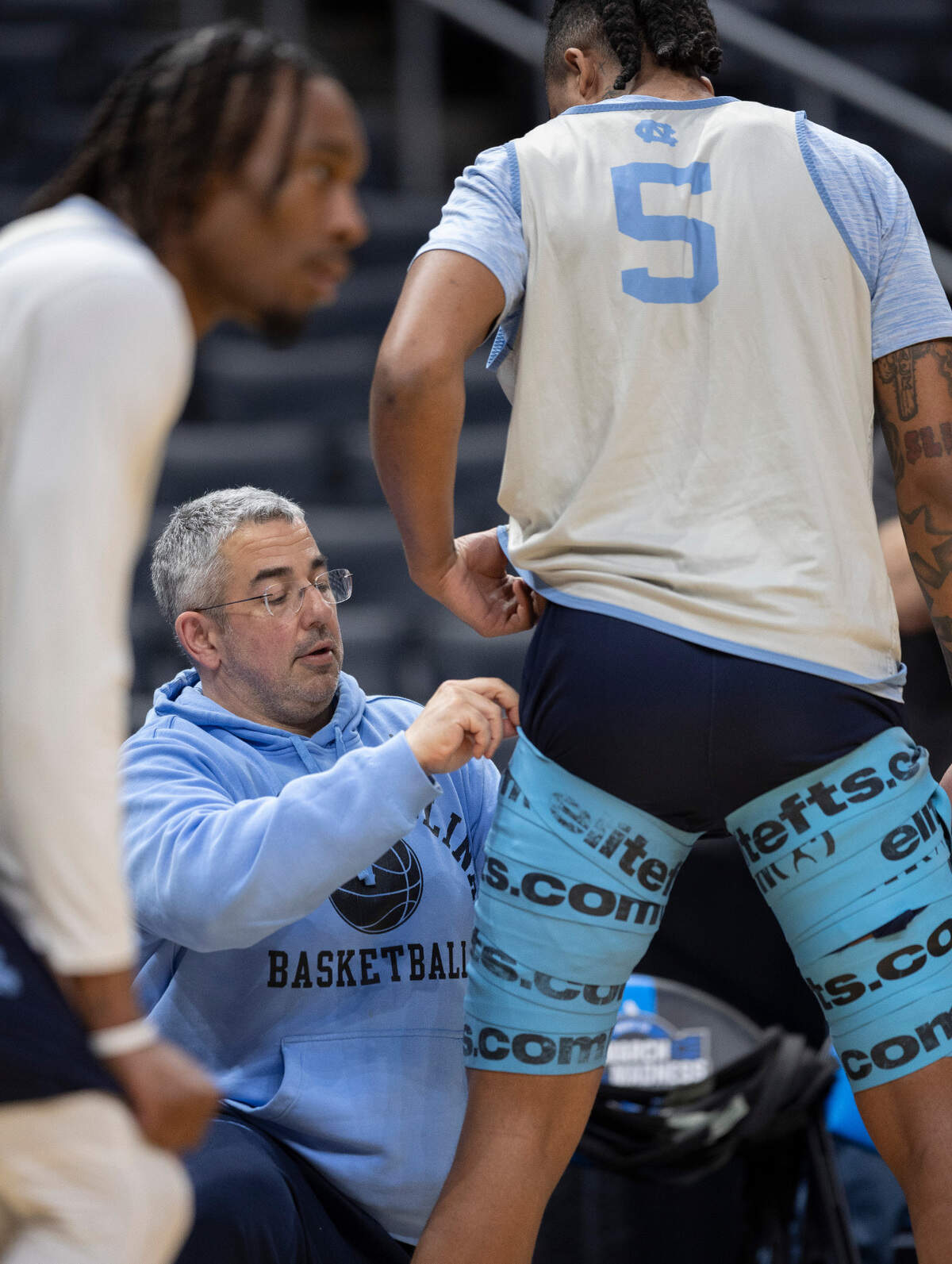 North Carolina strength and condition coordinator Jonas Sahratian wraps Armando Bacot with Voodoo Floss to better enable his stretching and mobility, prior to their workout on Wednesday, March 27, 2024 at Crypto.com Arena in Los Angeles, CA.