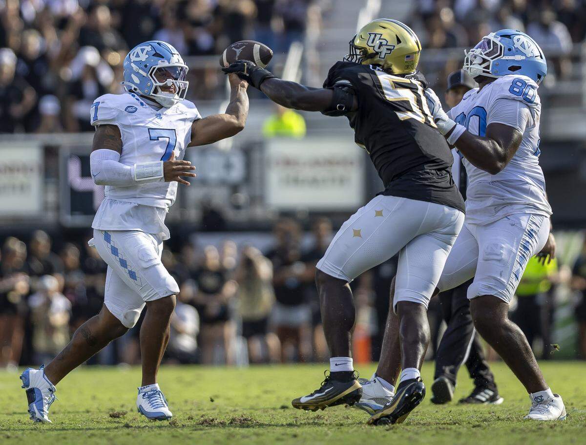 North Carolina quarterback Gio Lopez (7) is pressured by UCF defensive end Malachi Lawrence (51) in the second quarter on Saturday, September 20, 2025 at Acrisure Bounce House Stadium in Orlando, Fla.