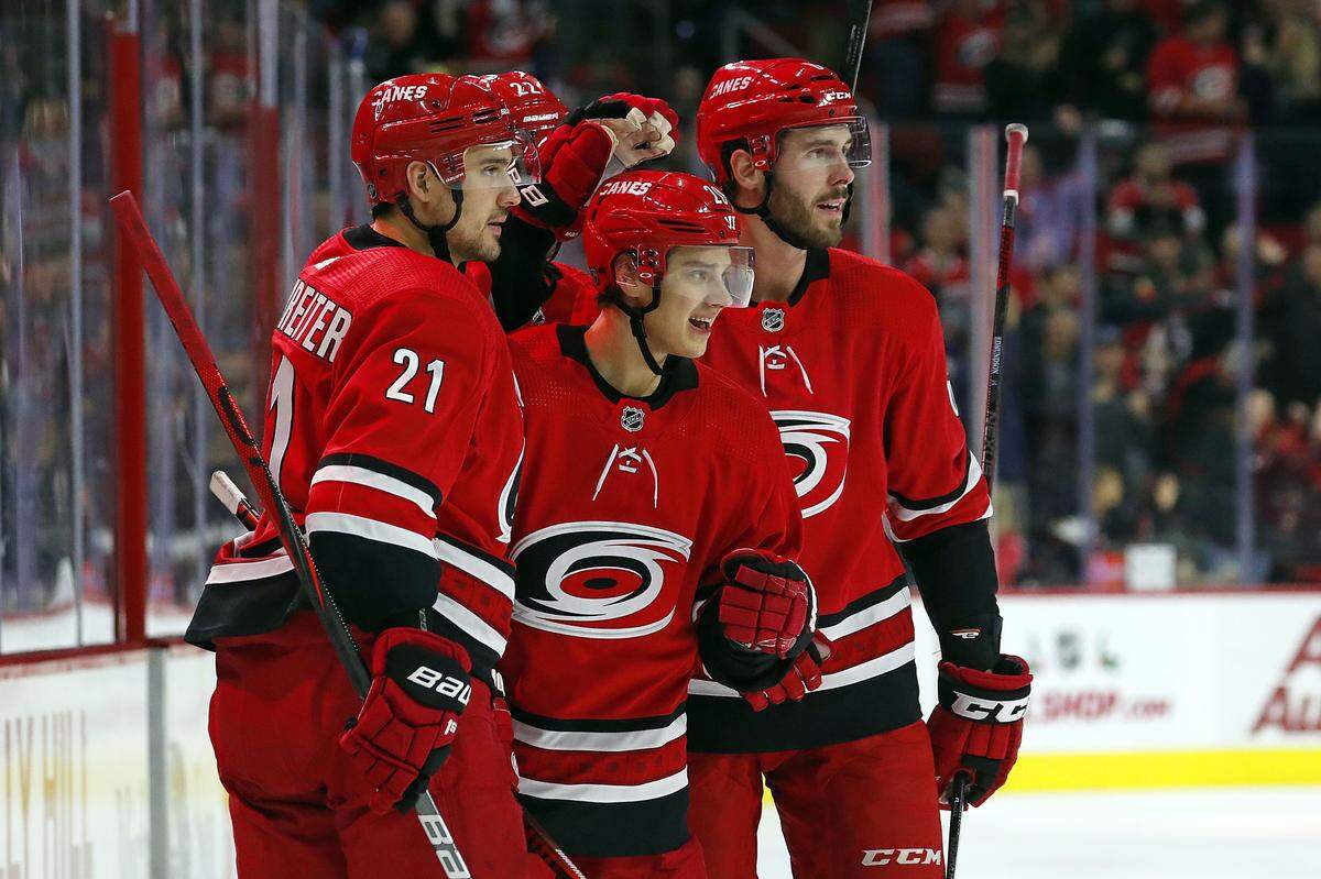Carolina Hurricanes’ Sebastian Aho (20) celebrates his goal against the Minnesota Wild with teammates Nino Niederreiter (21) and Joel Edmundson, right, during the second period of an NHL hockey game in Raleigh, N.C., Saturday, Dec. 7, 2019. (AP Photo/Karl B DeBlaker)