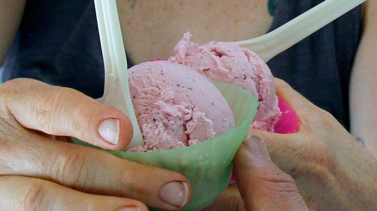 Two serving of ice cream go from the hands of Yoni Mazuz to Vanessa Mazuz as they fill orders during a busy lunch period in The Parlour.