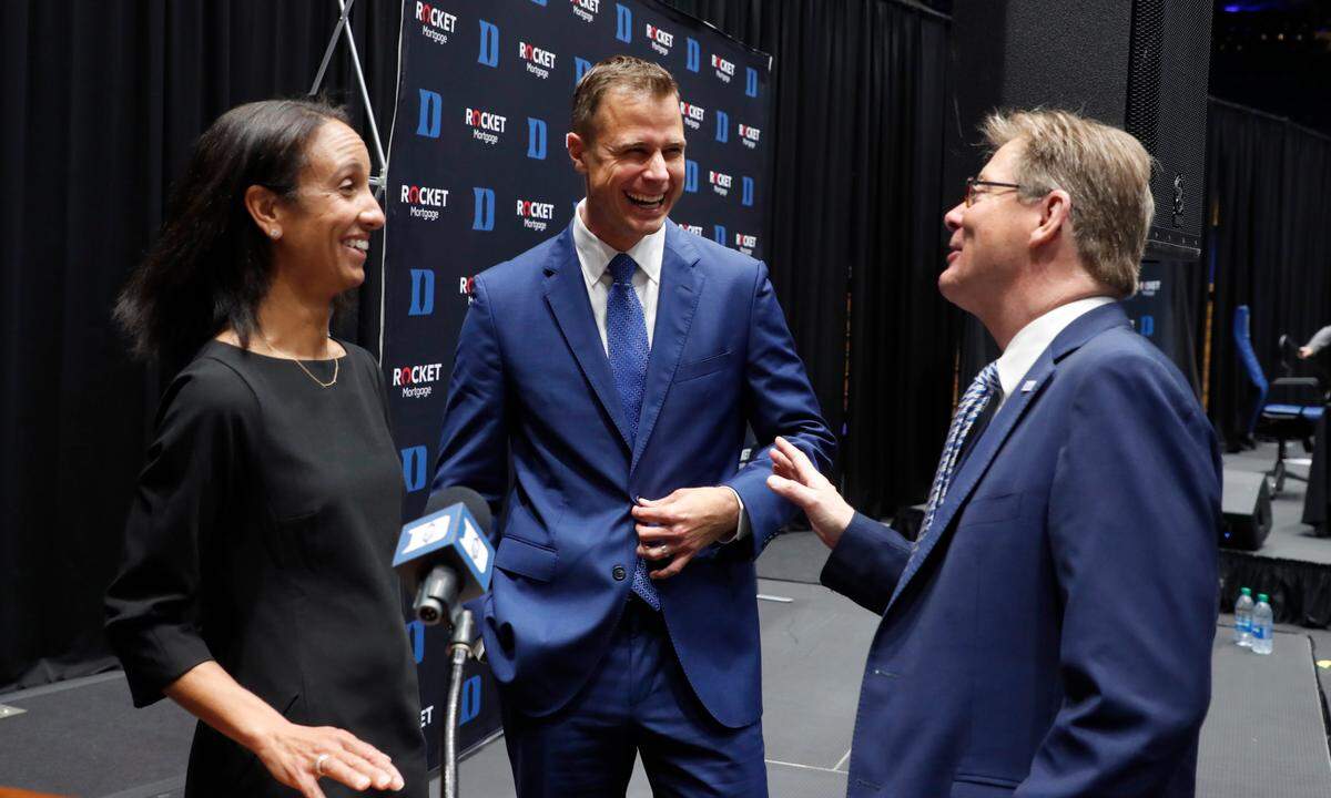 Jon Scheyer, center, laughs with Nina King, Duke’s incoming athletic director and President Vincent Price after Scheyer was introduced as Duke basketball’s 20th head coach during a press conference at Cameron Indoor Stadium in Durham, N.C., Friday, June 4, 2021.