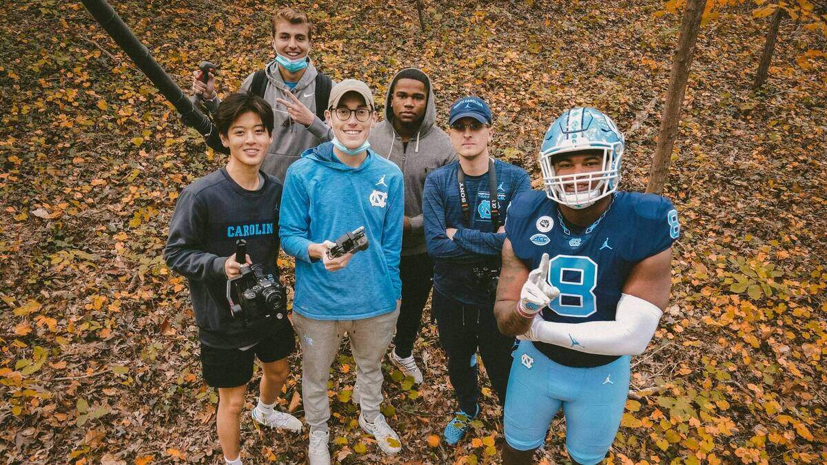 North Carolina football’s social media team poses with defensive lineman Myles Murphy (8) for a photo during a video shoot promoting their uniform combination for the UNC-Wake Forest game earlier this month.
