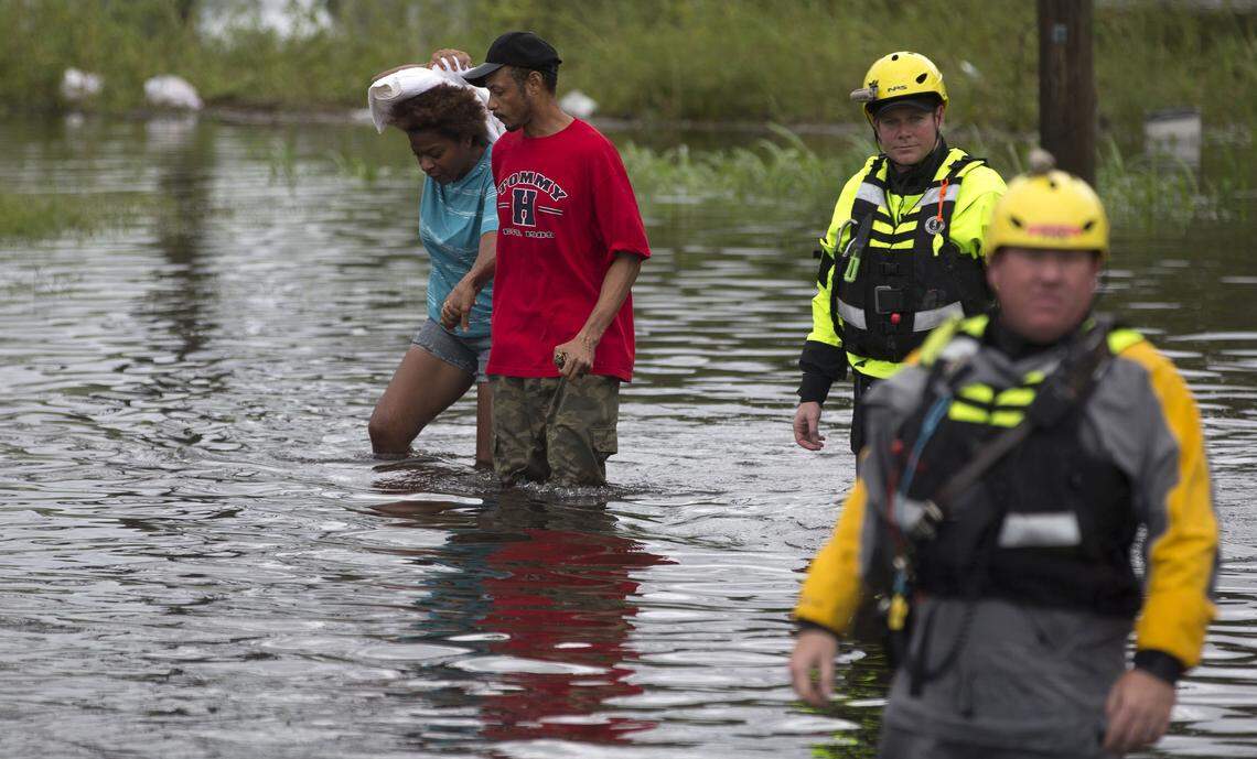 Members of the Greenville Fire Department swift water team help a couple evacuate their home following Hurricane Florence along Cedar Street on Friday morning September 15, 2018 in New Bern, N.C.