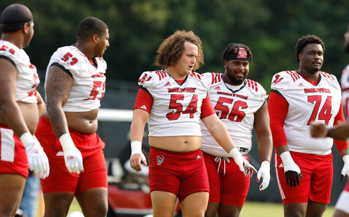 The N.C. State offensive line, from left, Timothy McKay (52), Derrick Eason (53), Dylan McMahon (54), Lyndon Cooper (56) and Anthony Belton (74) prepare to run a drill during the Wolfpack’s first fall practice in Raleigh, N.C., Wednesday, August 2, 2023.