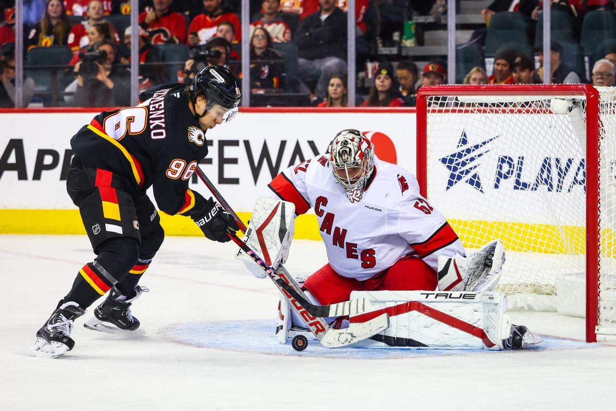Oct 24, 2024; Calgary, Alberta, CAN; Carolina Hurricanes goaltender Pyotr Kochetkov (52) makes a save against Calgary Flames left wing Andrei Kuzmenko (96) during the third period at Scotiabank Saddledome. Mandatory Credit: Sergei Belski-Imagn Images