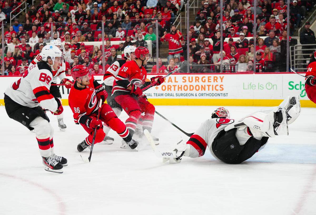 Dec 28, 2024; Raleigh, North Carolina, USA; Carolina Hurricanes center Jack Roslovic (96) scores a goal past New Jersey Devils goaltender Jake Allen (34) during the third period at Lenovo Center. Mandatory Credit: James Guillory-Imagn Images