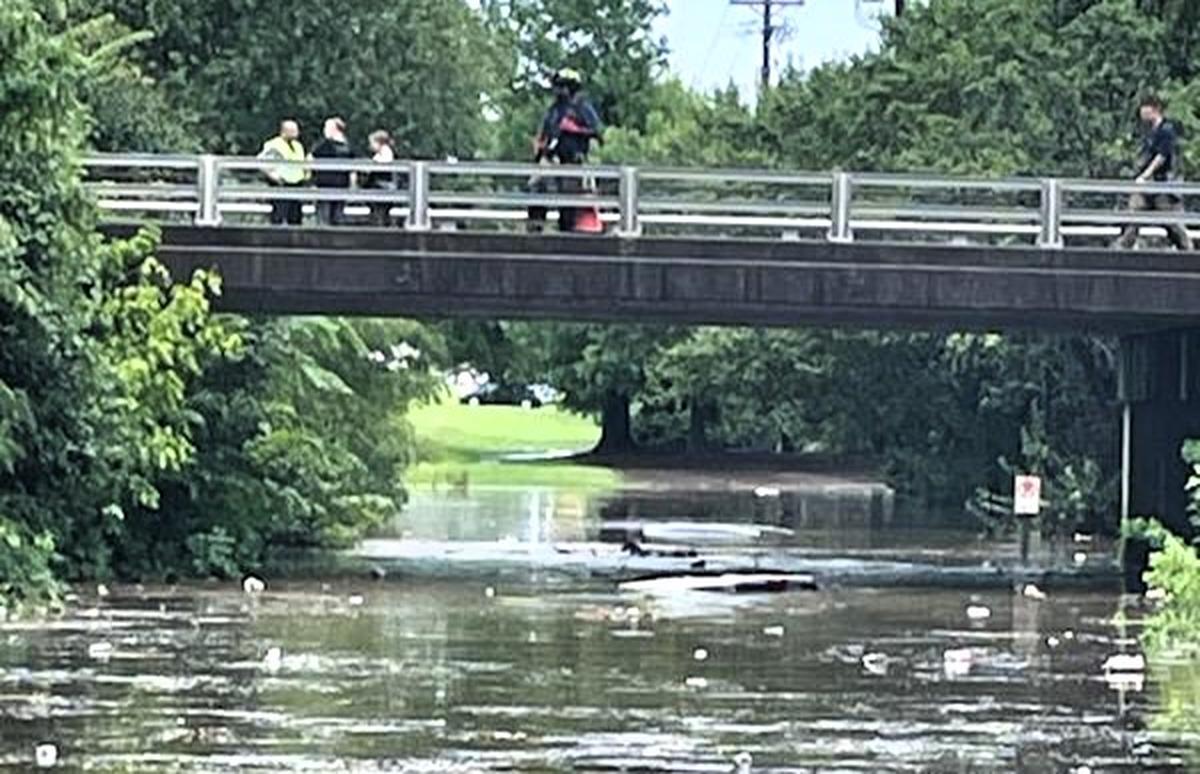 Durham County Sheriff’s Office Deputy P. Clark and a passing driver rescued another driver who underestimated flash flood conditions on July 22, 2024, at South Square shopping center in Durham. The roof of the stranded driver’s white SUV (at center) can barely be seen in this photo.
