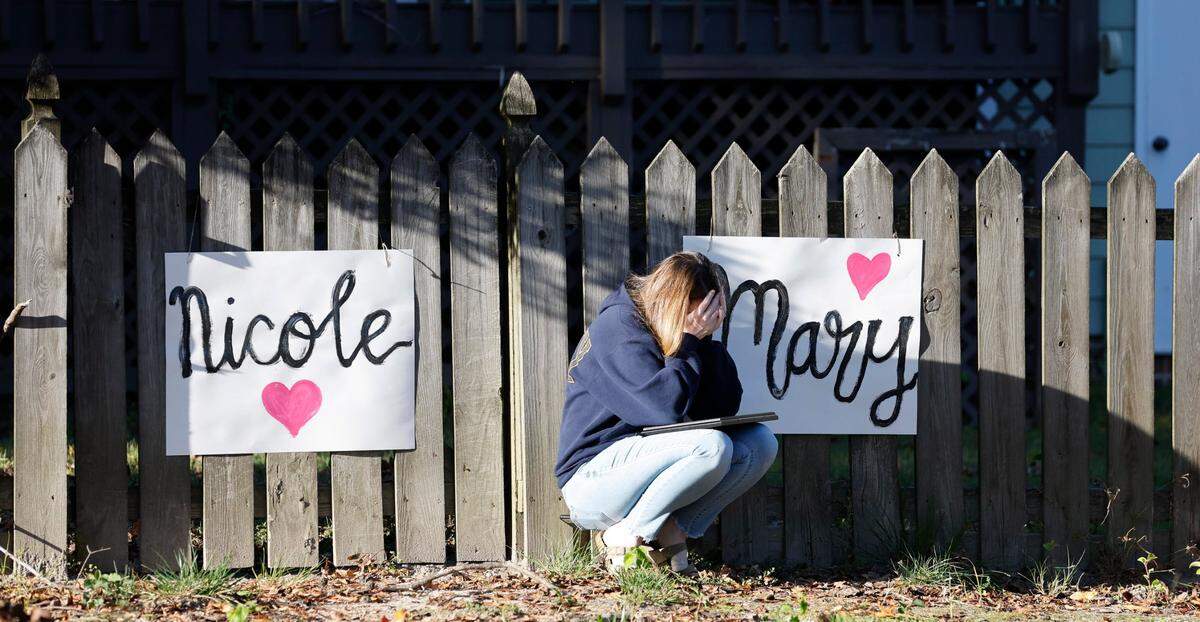 Mourners grieve after a candlelight vigil Saturday, Oct.15, 2022, for those killed and wounded in a mass shooting in the Hedingham neighborhood in Raleigh, N.C., on Thursday.