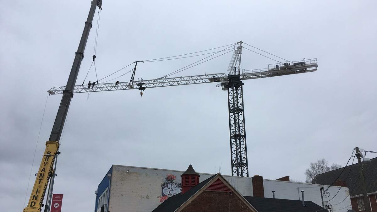 Workers begin to remove an abandoned construction crane on Saturday, March 9, 2019, that had been built near the intersection of Hillsborough and Horne streets in Raleigh.