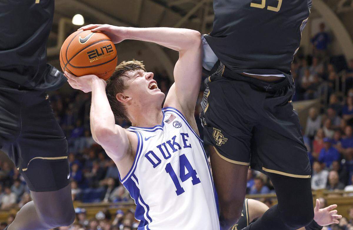 Duke’s Nikolas Khamenia (14) is pressured by UCF’s John Bol (7) and Devan Cambridge (35) during the first half of Duke’s exhibition game against UCF at Cameron Indoor Stadium in Durham, N.C., Tuesday, Oct. 21, 2025.