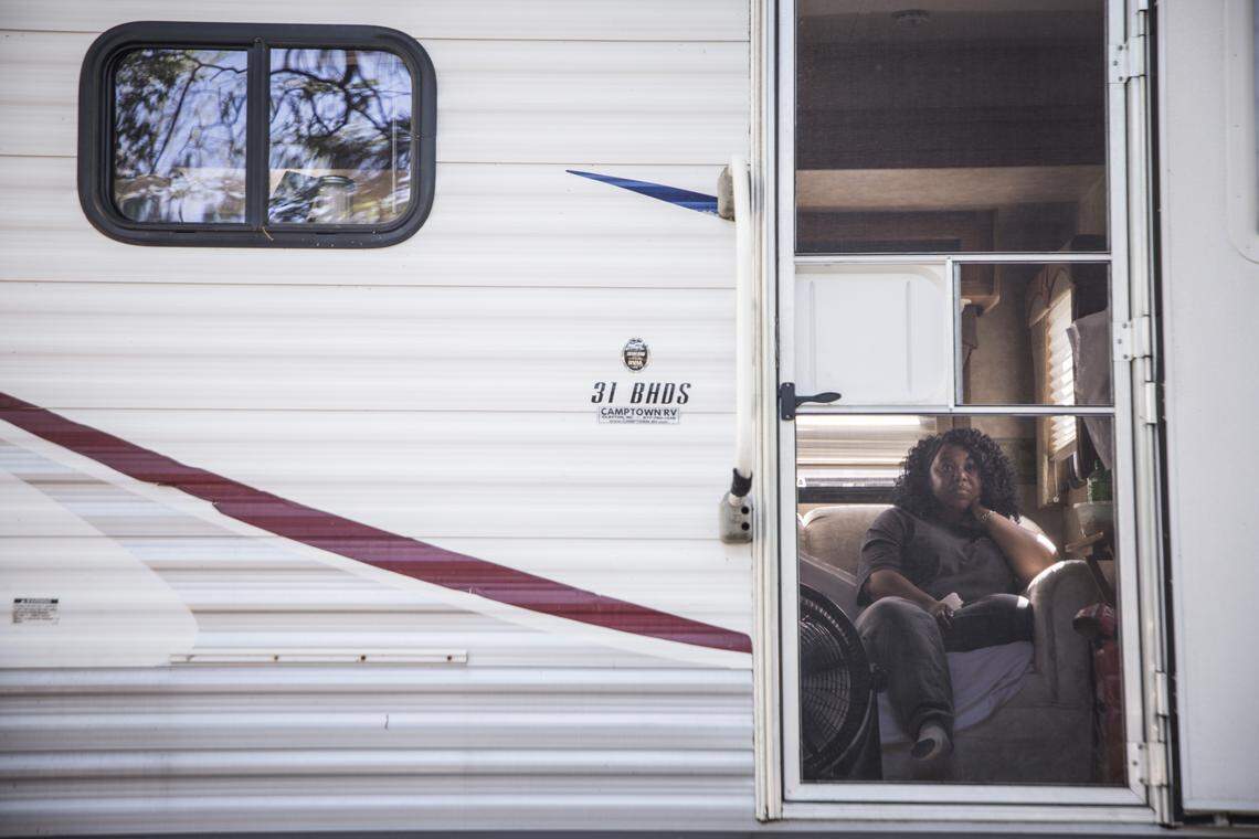 Shemeka Hand watches television in the travel trailer she and her family occupy behind their Hurricane Florence damaged home off Whitestocking Road near Burgaw in April 2020. The family had been displaced from their home for almost two years. 