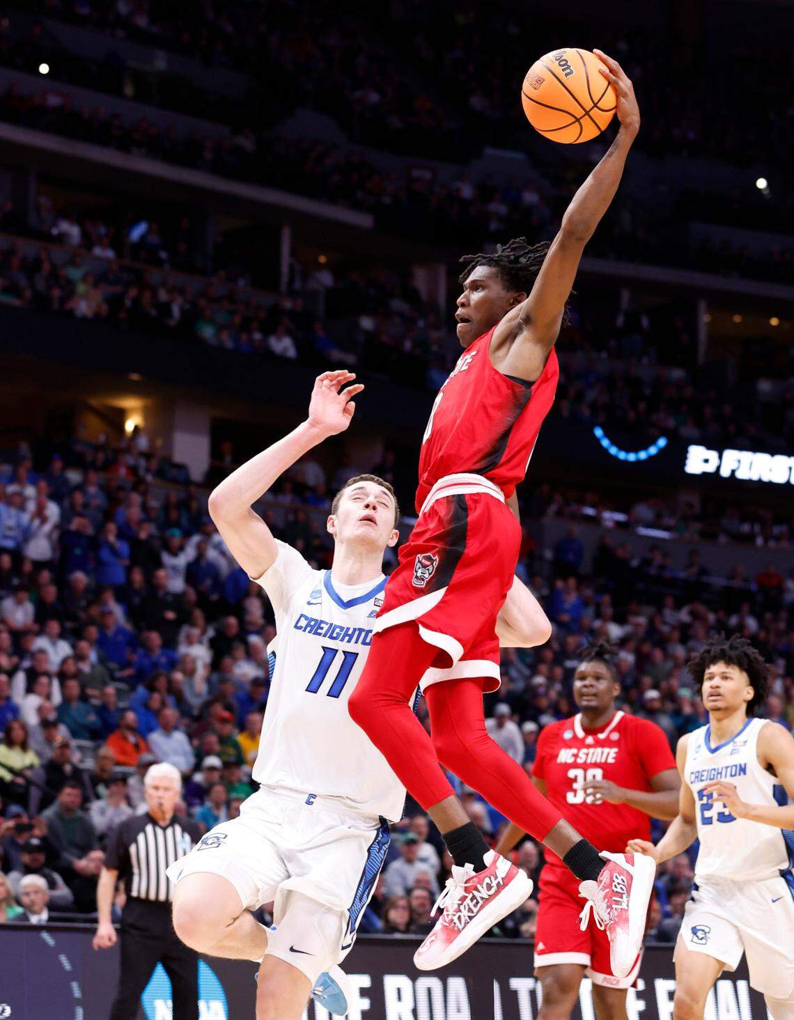 N.C. State’s Terquavion Smith (0) heads to slam in two past Creighton’s Ryan Kalkbrenner (11) during the second half of Creighton’s 72-63 victory over N.C. State in the first round of the NCAA Tournament at Ball Arena in Denver, Colo., Friday, March 17, 2023.