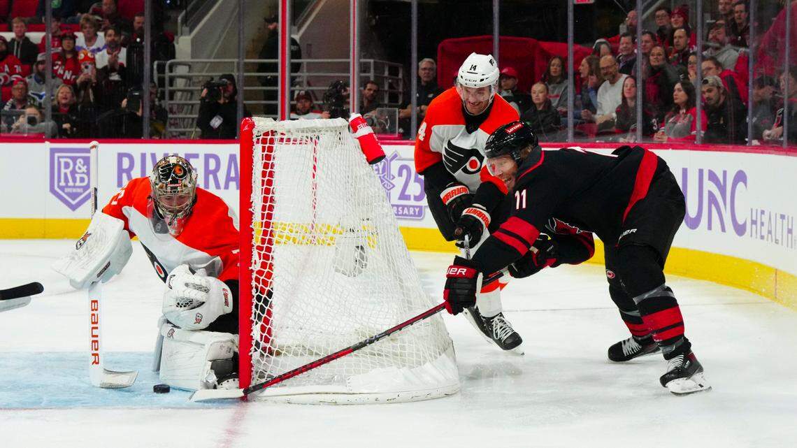 Nov 15, 2023; Raleigh, North Carolina, USA; Philadelphia Flyers goaltender Carter Hart (79) and center Sean Couturier (14) stop the scoring attempt by Carolina Hurricanes center Jordan Staal (11) during the first period at PNC Arena. Mandatory Credit: James Guillory-USA TODAY Sports