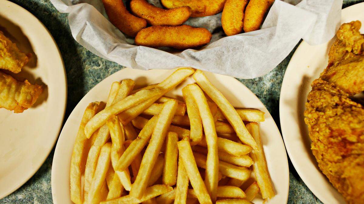 D.G. Martin orders seafood family style which comes with plates filled with boiled potatoes, fried shrimp, fish and chicken and a bowl of coleslaw and another one of Brunswick stew at Holt Lake Bar-B-Q & Seafood in Smithfield on Sept. 20, 2016.