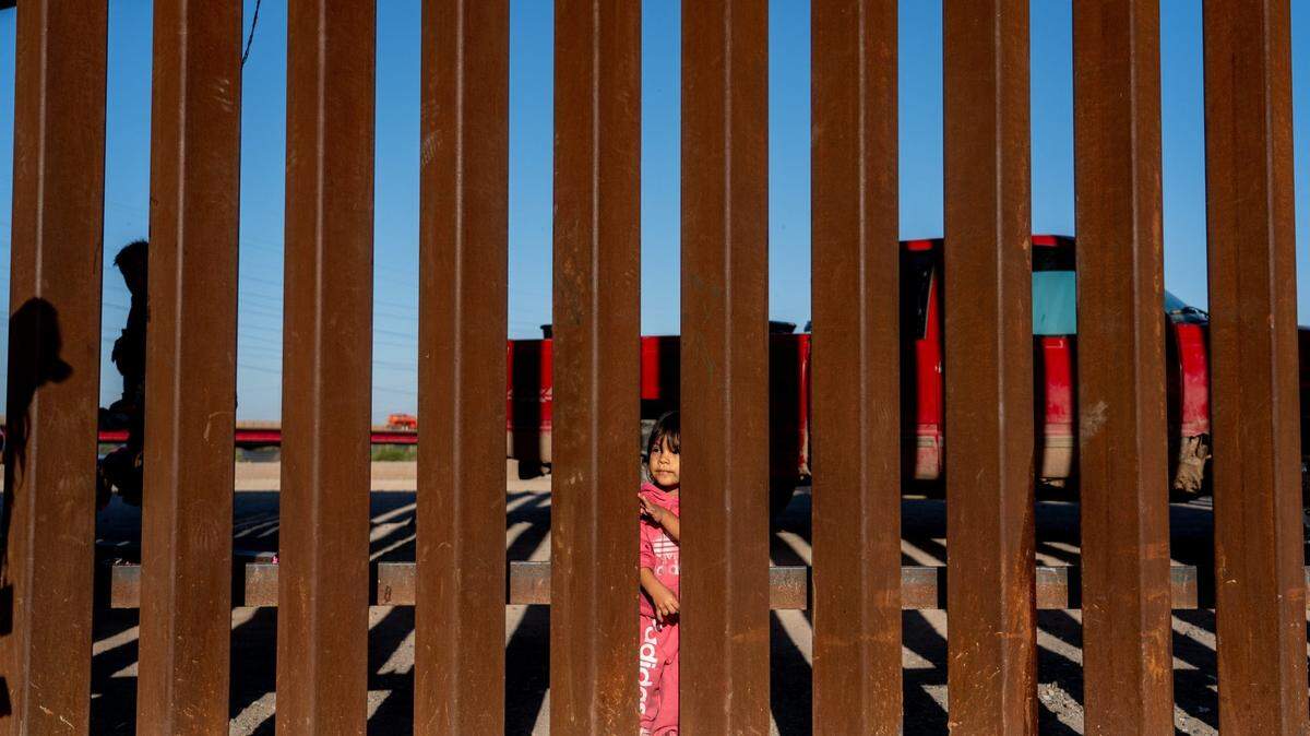 Migrants and asylum seekers from Peru wait for Border Patrol agents to pick them up after crossing the U.S.-Mexico border in San Luis, Ariz., on May 12, 2023.
