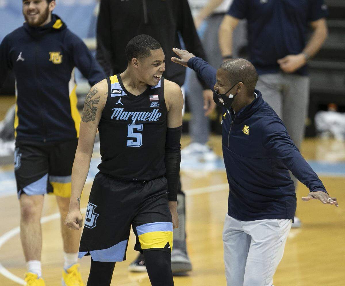 Marquette associate head coach Justin Gainey assistant celebrates with Greg Elliott (5) after defeating North Carolina 83-70 in 2021 at the Smith Center in Chapel Hill, N.C.