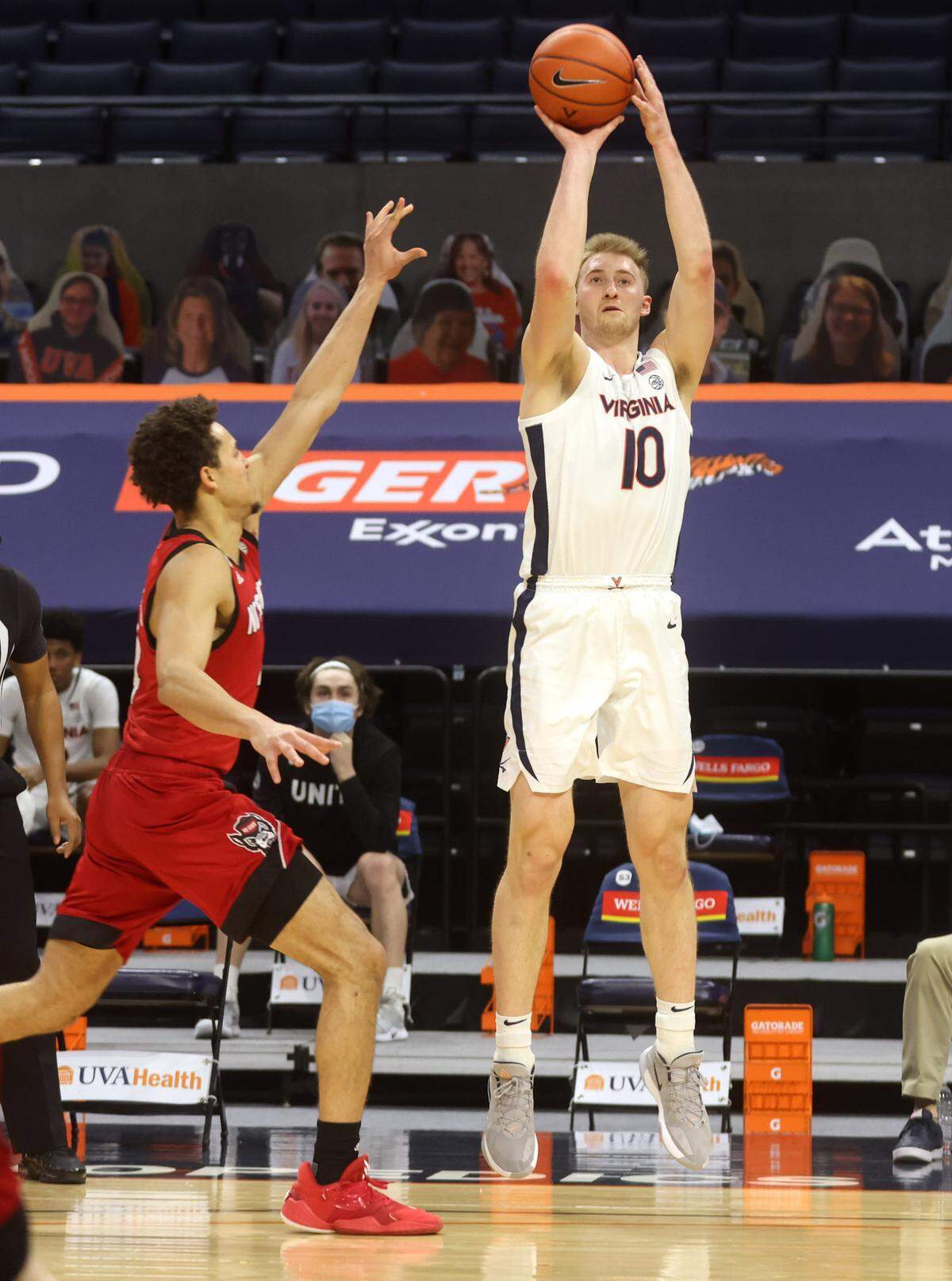 Virginia forward Sam Hauser (10) shoots next to North Carolina State forward Jericole Hellems (4) during the game Wednesday in Charlottesville, Va. North Carolina State defeated Virginia 68-61.