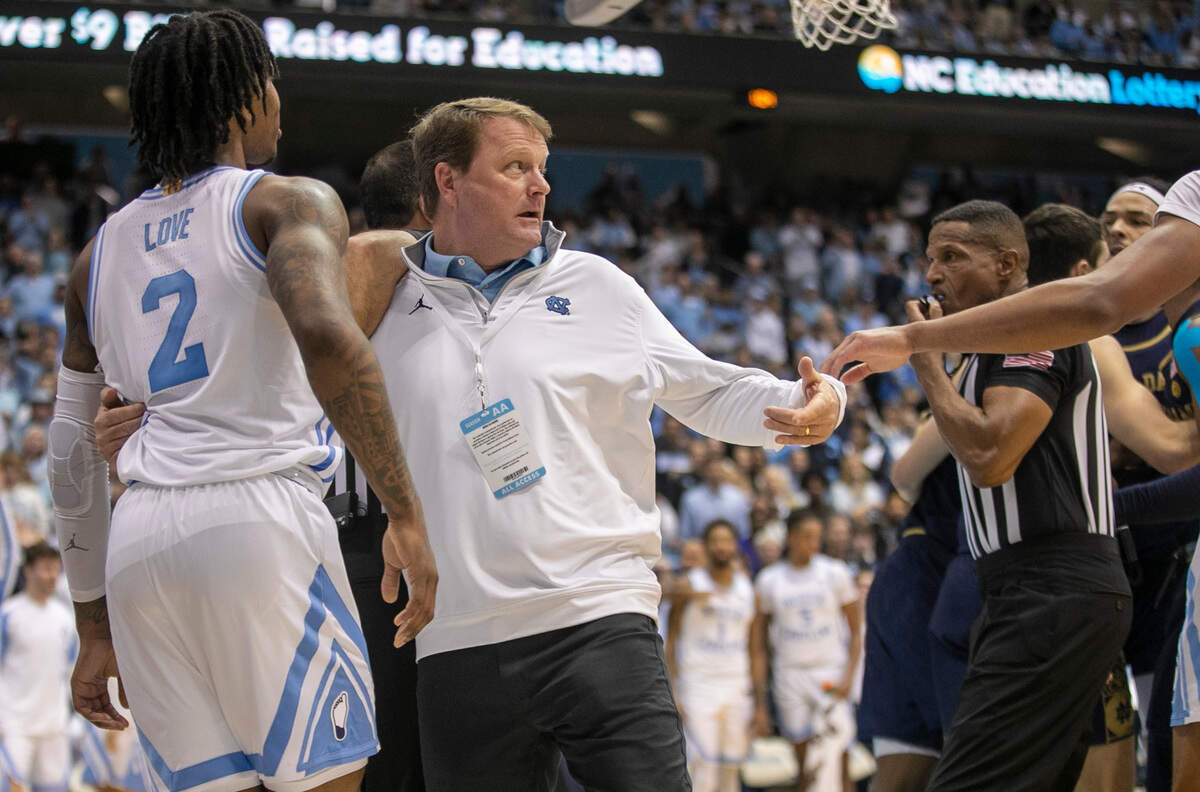 North Carolina associate athletic director Clint Gwaltney restrains Caleb Love after an altercation in the second half against Notre Dame on Saturday, January 7, 2023 at the Smith Center in Chapel Hill, N.C.