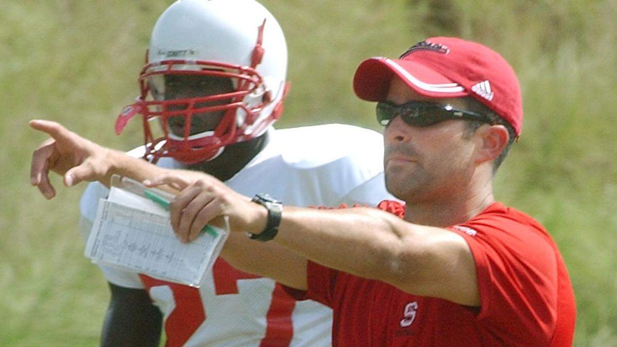 N.C. State coach Manny Diaz yells directions to the punt team as Troy Graham (27) looks on during practice in 2004.