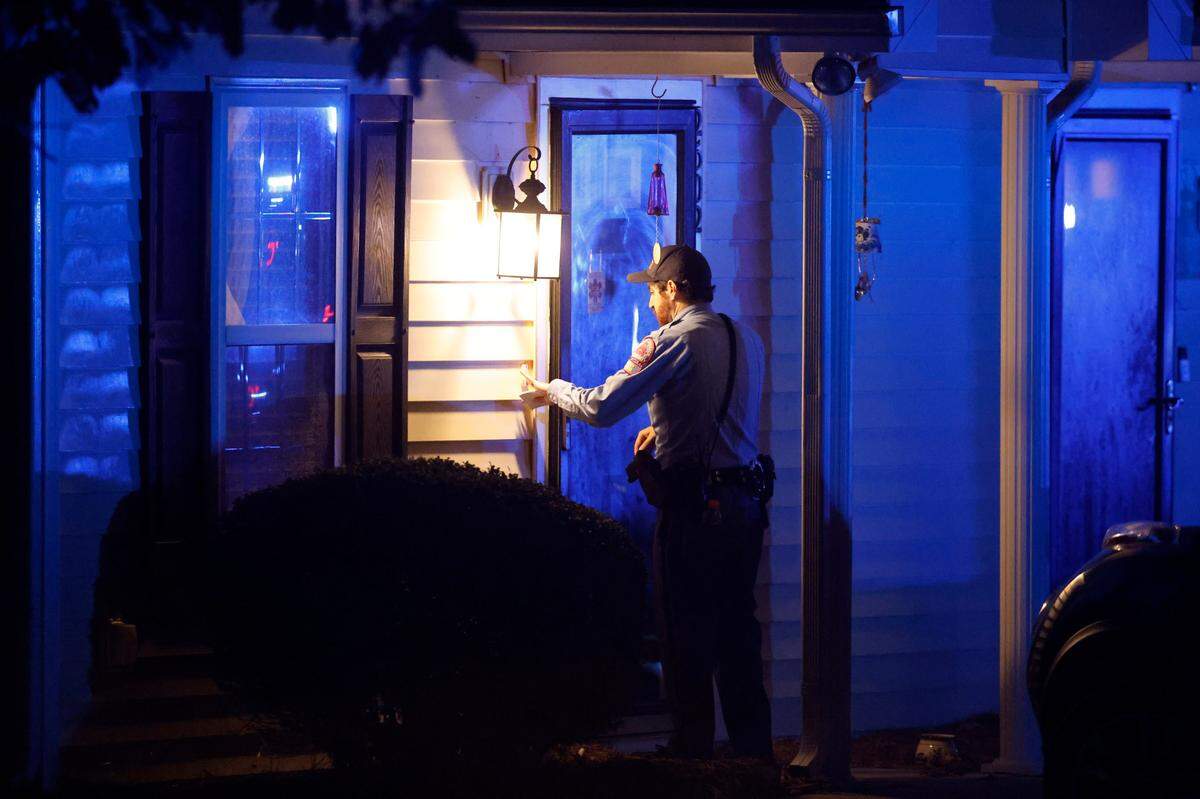 Raleigh police go door to door to ask residents if they are ok and if everyone in their family is accounted for Thursday evening, Oct. 13, 2022, in the Hedingham neighborhood in Raleigh, N.C.