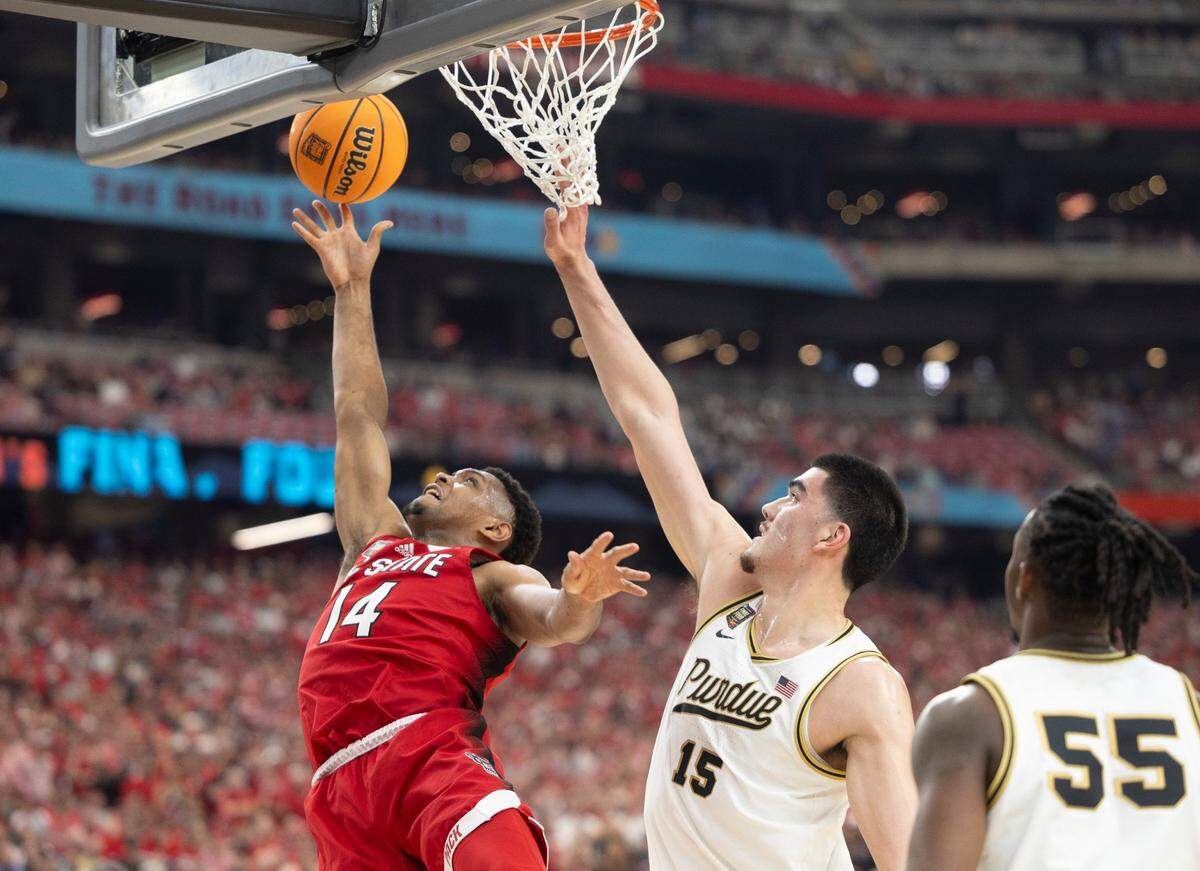 N.C. Casey Morsell (14) drives to the basket against Purdue’s Zach Edey (15) during the first half in the NCAA Final Four National Semifinal game on Saturday, April 6, 2024 at State Farm Stadium in Glendale, AZ.