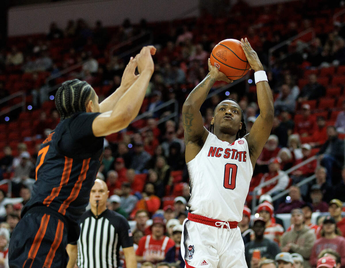 N.C. State’s DJ Horne shoots over Miami’s Kyshawn George during the first half of the Wolfpack’s 74-68 win on Tuesday, Jan. 30, 2024, at PNC Arena in Raleigh, N.C.