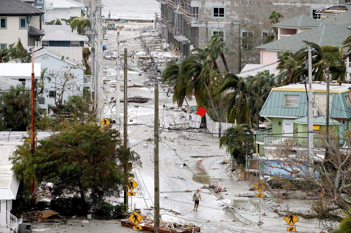 A man walks through a street among damaged homes and businesses and debris in Fort Myers Beach, Fla., on Thursday, Sep 29, 2022, following Hurricane Ian.