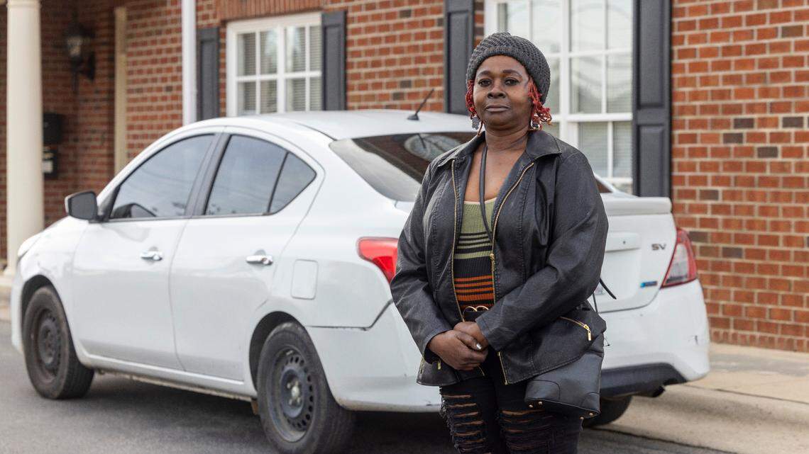 Jacqueline McNeill, of Hope Mills, stands by the white Nissan Versa she was driving the day she was wrongly arrested in Fayetteville in 2022.