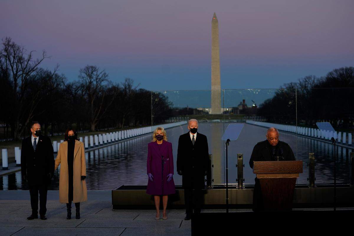 **EDS. RETRANSMISSION TO RECAST THROUGHOUT** President-elect Joe Biden and his wife Jill, along with Vice President-elect Kamala Harris and her husband Doug Emhoff, listen as Cardinal Wilton Gregory, Archbishop of Washington, delivers the invocation during a COVID-19 memorial at the Lincoln Monument Reflecting Pool in Washington on Tuesday evening, Jan. 19, 2021. Pope Francis elevated Gregory to the rank of cardinal on Nov. 28, 2020. He is the first African American cardinal.