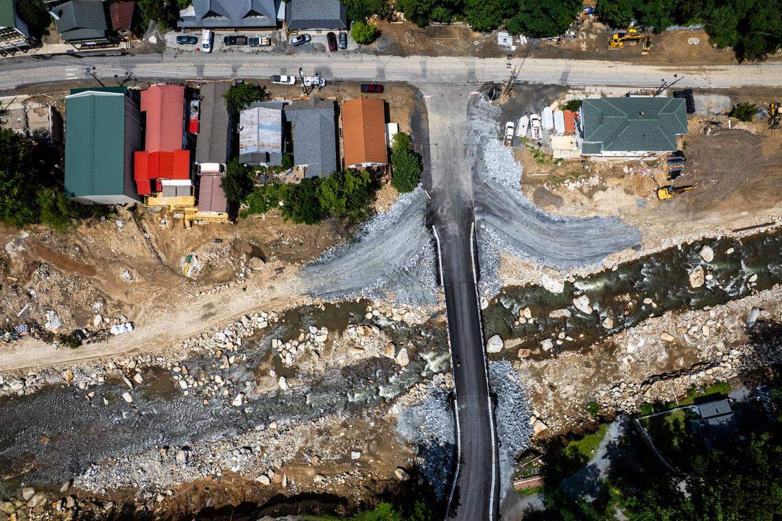 An aerial view shows a newly completed temporary bridge spanning the Broad River and connecting U.S. 64/74A to Chimney Rock State Park, surrounded by road construction and debris cleanup on Friday, June 13, 2025, in Chimney Rock. The bridge replaces one destroyed by Hurricane Helene. A temporary road now connects Bat Cave and Chimney Rock after the storm wiped out a 2.5-mile stretch of highway through Hickory Nut Gorge—one of the most severely damaged and costly road repairs in the state.