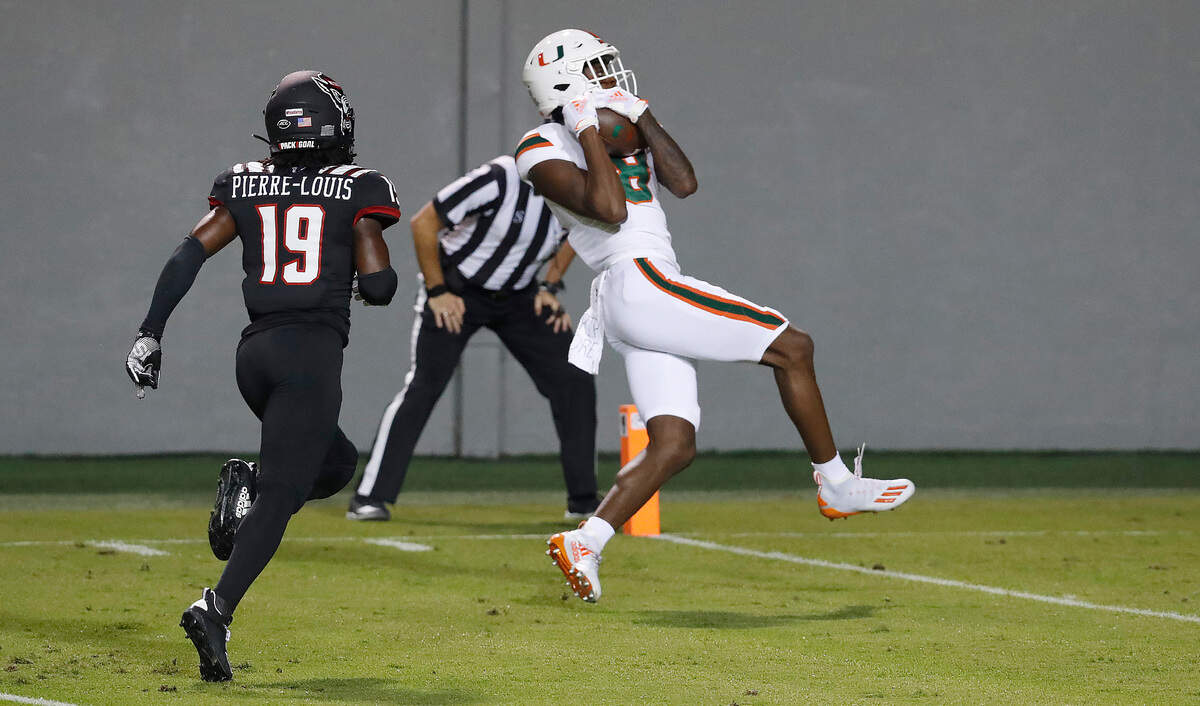 Miami wide receiver Dee Wiggins (8) pulls in a 39-yard touchdown reception as N.C. State defensive back Joshua Pierre-Louis (19) trails during the first half of N.C. State’s game against Miami at Carter-Finley Stadium in Raleigh, N.C., Friday, Nov. 6, 2020.
