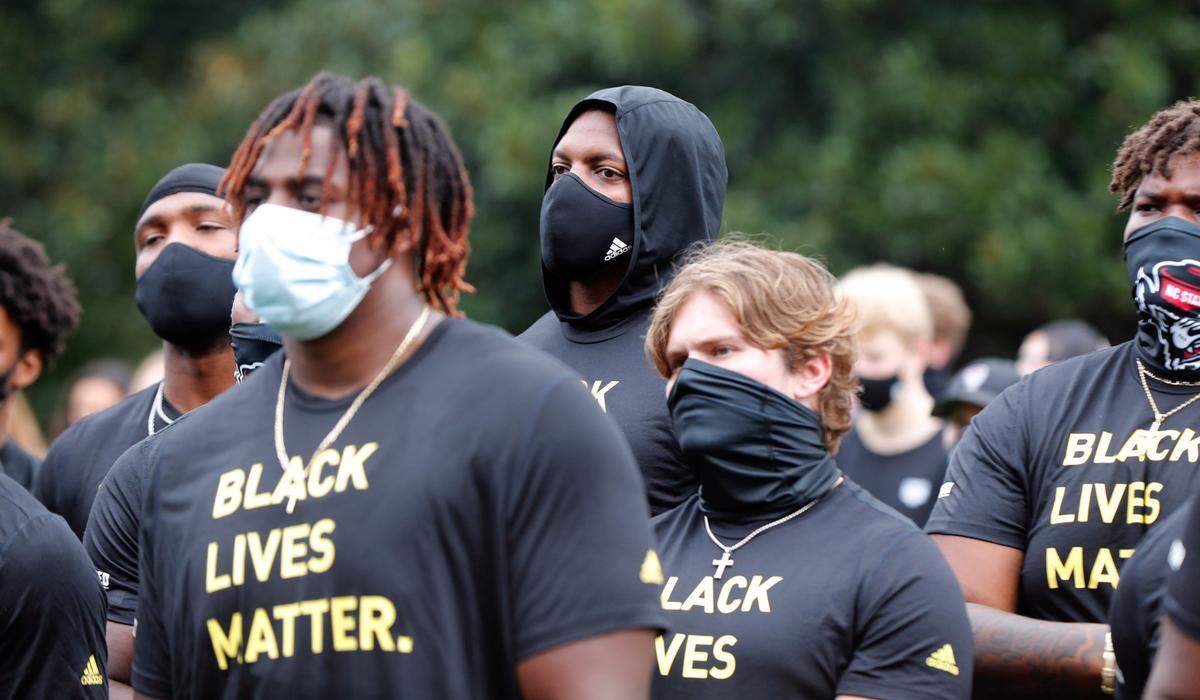 N.C. State athletes, coaches and staff listen to the speakers during a #PackUnited peaceful protest against racial and social injustice outside Holladay Hall on the campus of N.C. State Saturday, Sept. 12, 2020.