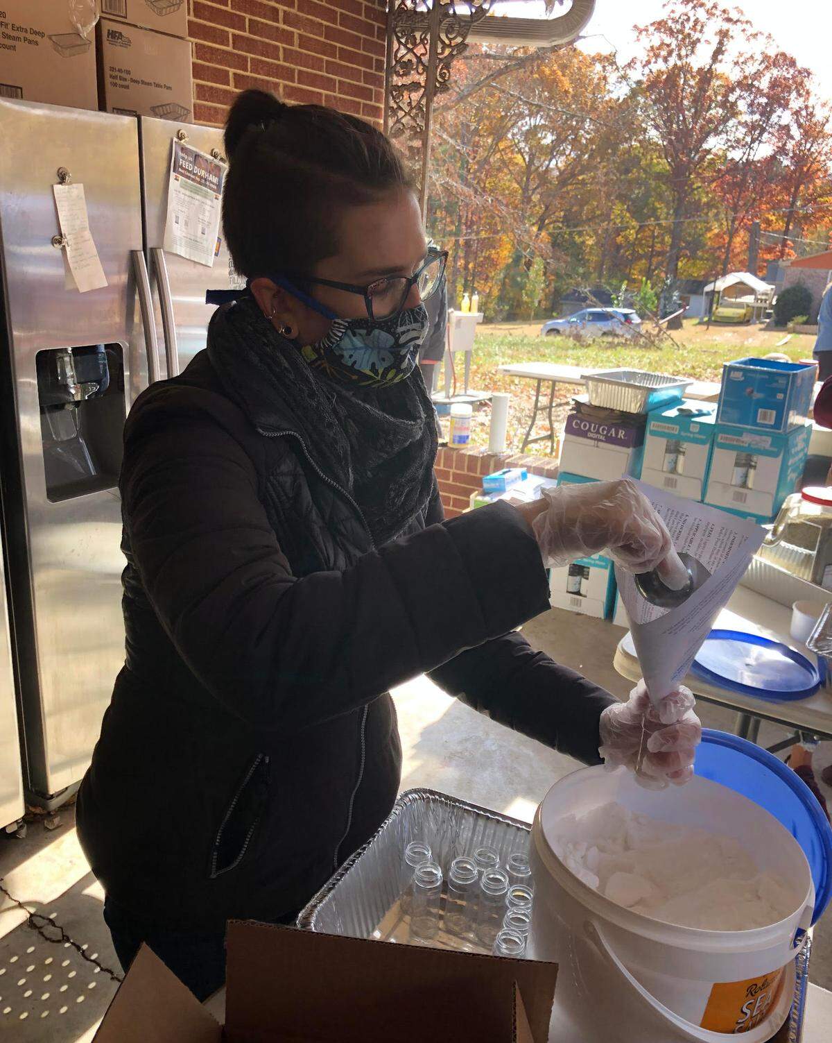 Beth Roessner of Durham, a volunteer with Feed Durham NC, fills dispensers with sea salt that will be packed into Thanksgiving 2021 grocery bags for those in need. The group planned to give away about 600 bags with the ingredients for a holiday meal on Saturday, Nov. 20.