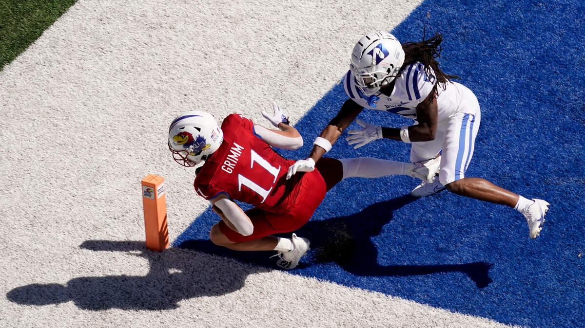 Kansas wide receiver Luke Grimm (11) is tackled in the end zone by Duke defensive back Datrone Young (5) after scoring a touchdown during the first half of an NCAA college football game Saturday, Sept. 24, 2022, in Lawrence, Kan.