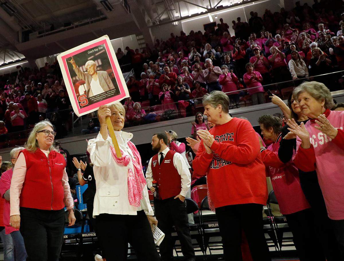 Reba Worsley, a cancer survivor of 28 years, holds a photo of former N.C. State head coach Kay Yow aloft during a ceremony at halftime of N.C. State’s Play4Kay Game against Louisville on Monday, Feb. 5, 2024, at Reynolds Coliseum in Raleigh, N.C.