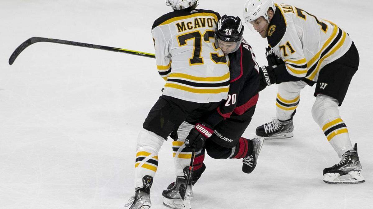 Boston Bruins Charlie McAvoy (73) checks Carolina Hurricanes Sebastian Aho (20) in the third period on Wednesday, May 4, 2022 during game two of their Stanley Cup first round series at PNC Arena in Raleigh, N.C.