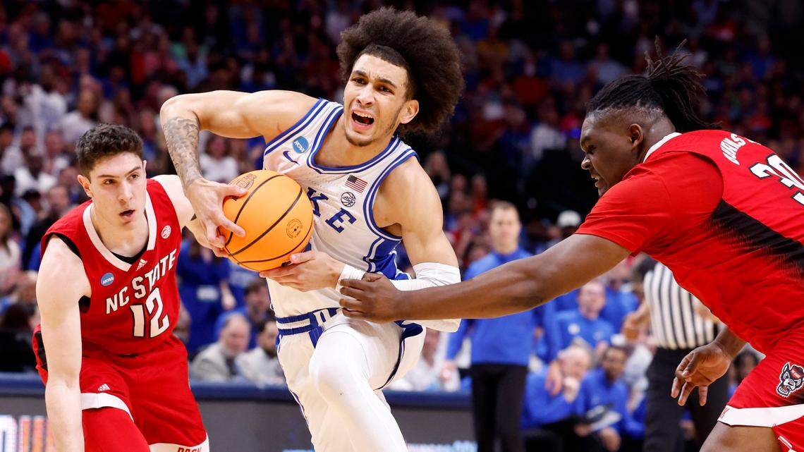 Duke’s Tyrese Proctor (5) drives past N.C. State’s DJ Burns Jr. (30) and Michael O’Connell (12) during the first half of N.C. State’s game against Duke in their NCAA Tournament Elite Eight matchup at the American Airlines Center in Dallas, Texas, Sunday, March 31, 2024.