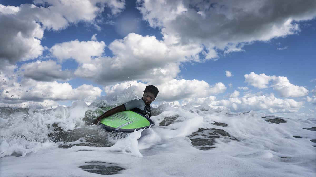 Sterling Stewart wades into the ocean at Wrightsville Beach. He took part in Surfers Healing, a camp teaching kids with autism how to surf. Today he surfs at least four days a week, and his family moved from Durham to Wilmington so he would be closer to the ocean.