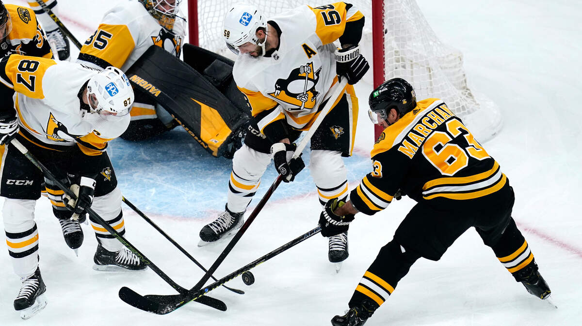 Pittsburgh Penguins defenseman Kris Letang (58) and center Sidney Crosby (87) stop a shot by Boston Bruins left wing Brad Marchand (63) after Penguins goaltender Tristan Jarry lost his balance during the first period of an NHL hockey game, Tuesday, Feb. 8, 2022. (AP Photo/Charles Krupa)