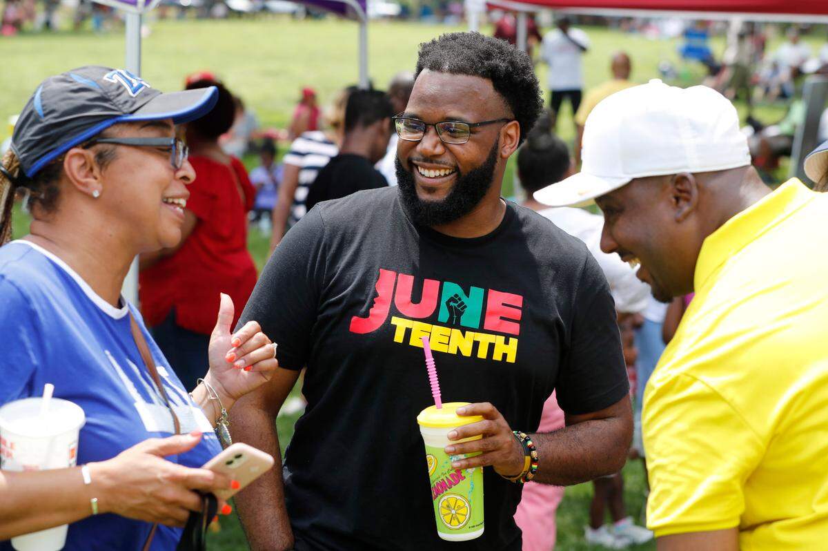 Gecolby Youngblood, center, and Robin Featherstone laugh while talking with Raleigh City Council member Corey Branch during the Capital City Juneteenth Celebration 2021 at Dorothea Dix Park in Raleigh, N.C., Saturday, June 19, 2021.