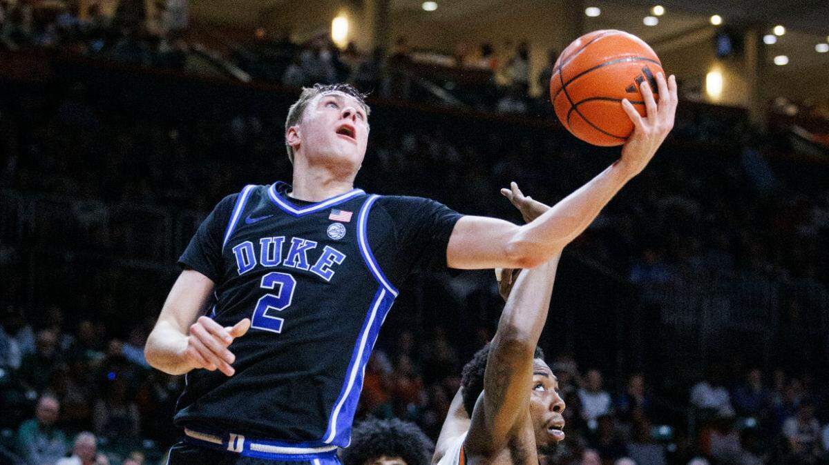 Duke Blue Devils guard Cooper Flagg (2) shoots a layup around Miami (Fl) Hurricanes forward Kiree Huie (15) during the first half of a game on Tuesday, Feb. 25, 2025, at Watsco Center in Coral Gables, Fla.