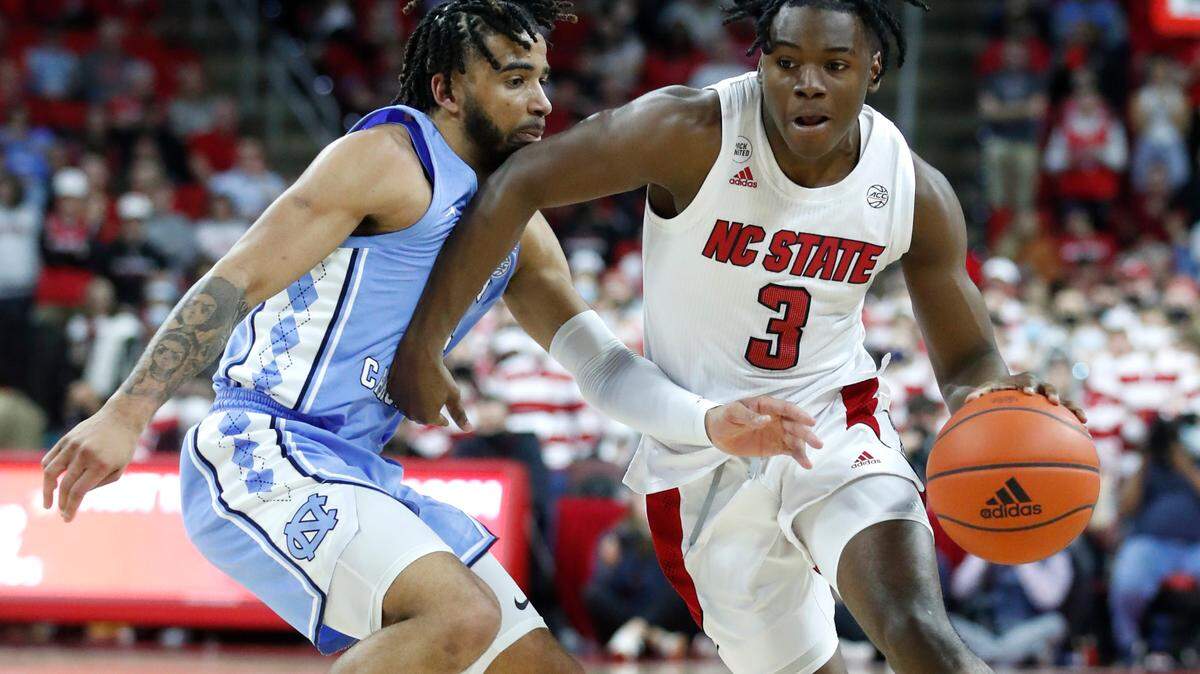 N.C. State’s Cam Hayes (3) drives around North Carolina’s R.J. Davis (4) during the second half of UNC’s 84-74 victory over N.C. State at PNC Arena in Raleigh, N.C., Saturday, Feb. 26, 2022.