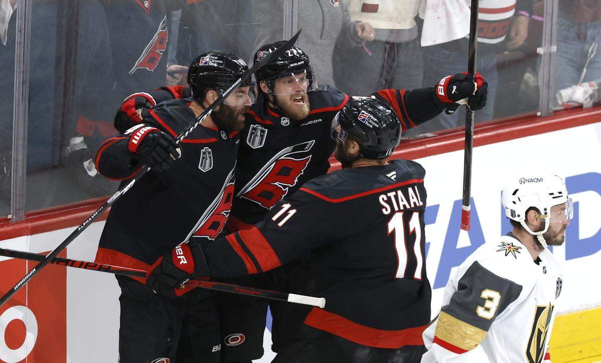 Carolina's Jordan Martinook (48) and Jordan Staal (11) celebrate with Nikolaj Ehlers (27) after he scored during the first period of the Hurricanes’ game against the Golden Knights in the first game of the Stanley Cup Final at the Lenovo Center in Raleigh, N.C., Tuesday, June 2, 2026.