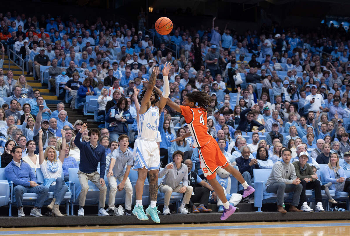 North Carolina’s R.J. Davis (4) launches a three-point shot over Syracuse’s Chris Bell (4) in the first half on Saturday, January 13, 204 at the Smith Center in Chapel Hill, N.C.