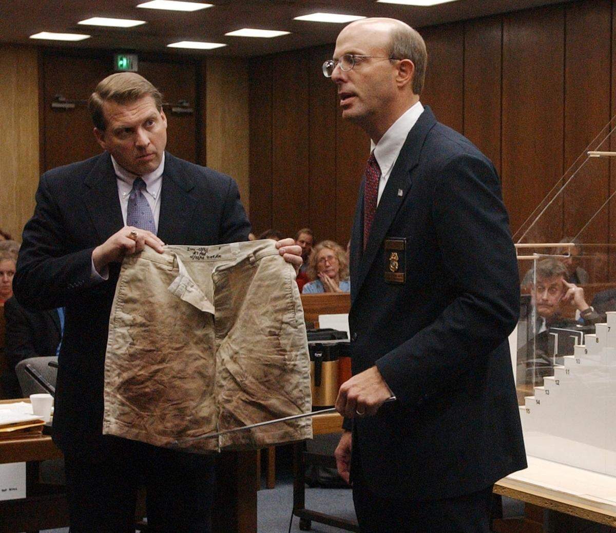 Durham District Attorney Jim Hardin, left, holds Michael Peterson’s blood stained shorts as State Bureau of Investigation blood spatter expert Duane Deaver gives his conclusion about the blood spatter evidence to the jury Monday, Aug.18, 2003.